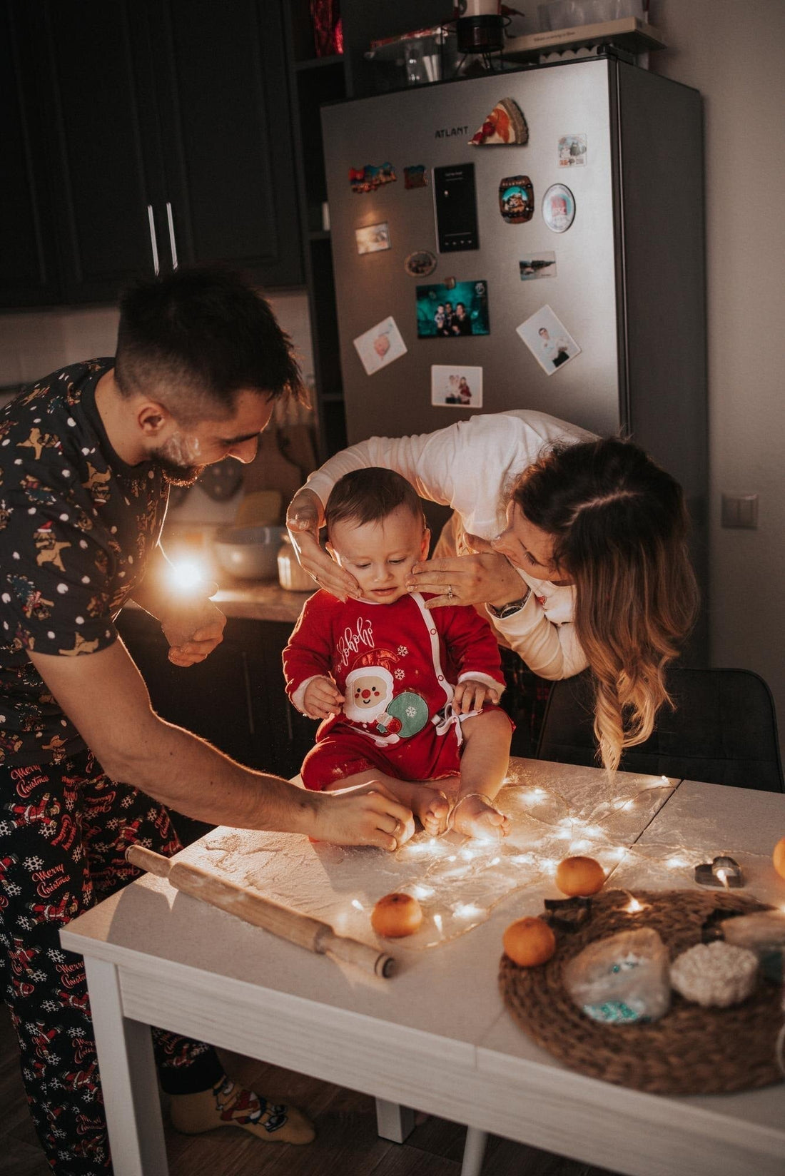 family with baby and Christmas lights